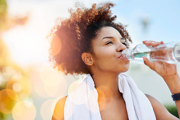 Woman drinking water after exercise