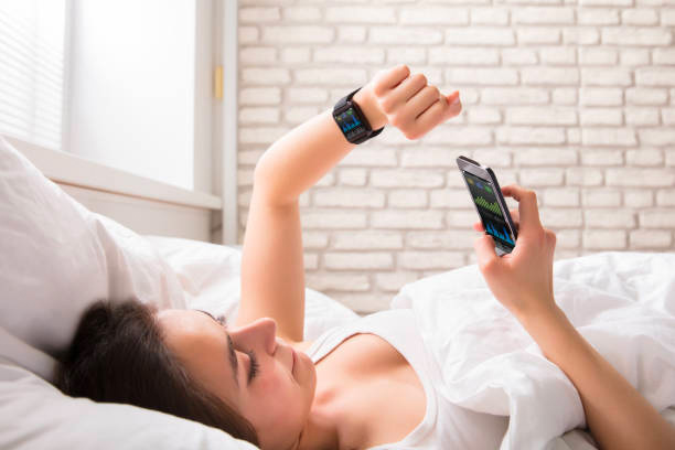 woman waking up checking sleep tracker